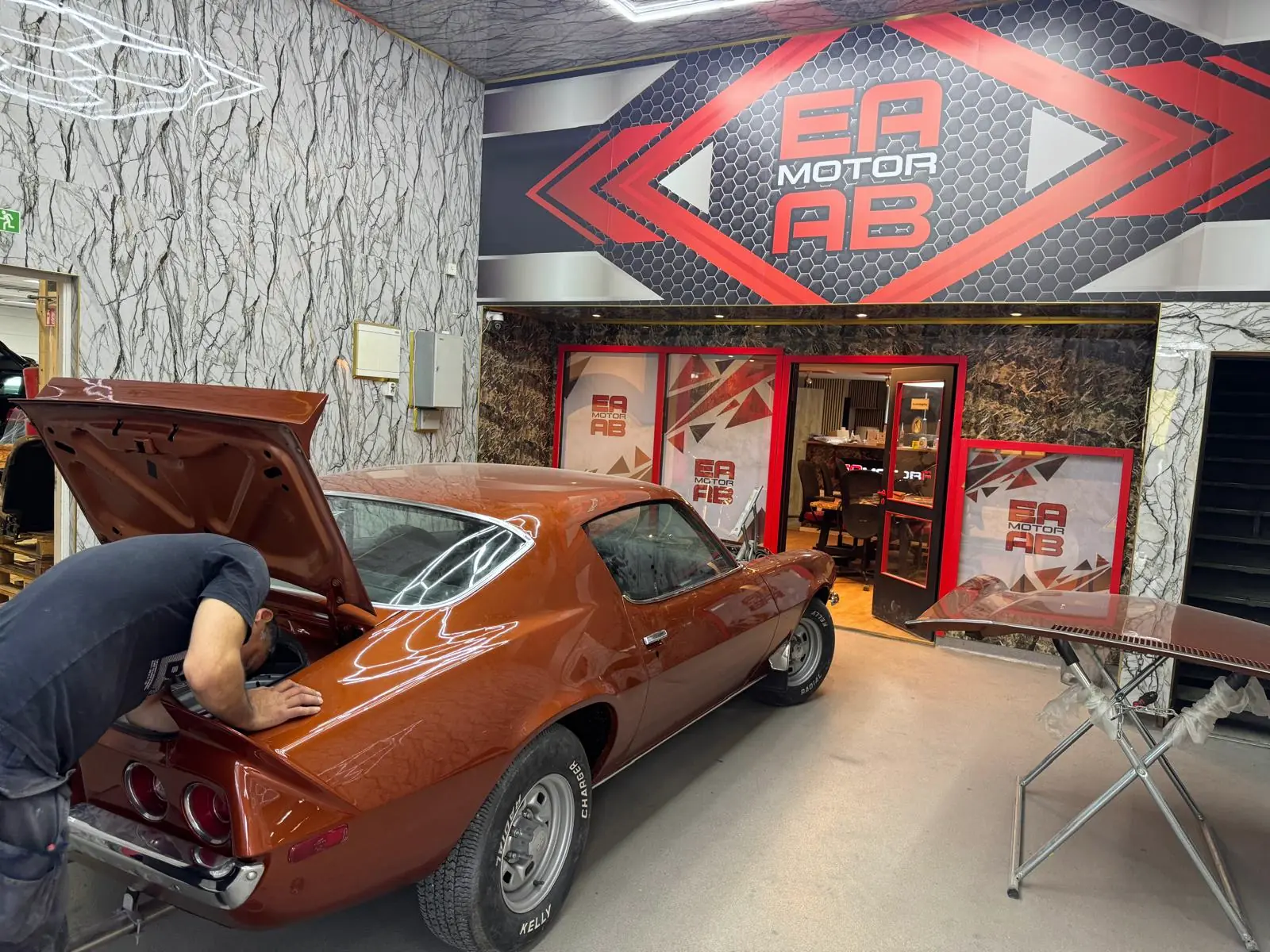 Mechanic working on a classic car in EA Motor's reception